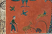 Wat Xieng Thong temple in Luang Prabang, Laos. Detail of the famous tree of life mosaic of the back wall of the sim, in colored glass on a dark red background. 